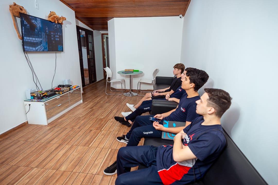 Alunos jogando videogame na área de convivência da CWB Idiomas